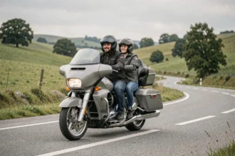 Couple à moto de tourisme confortable sur une route de campagne, passager avec dossier, équipement textile assorti